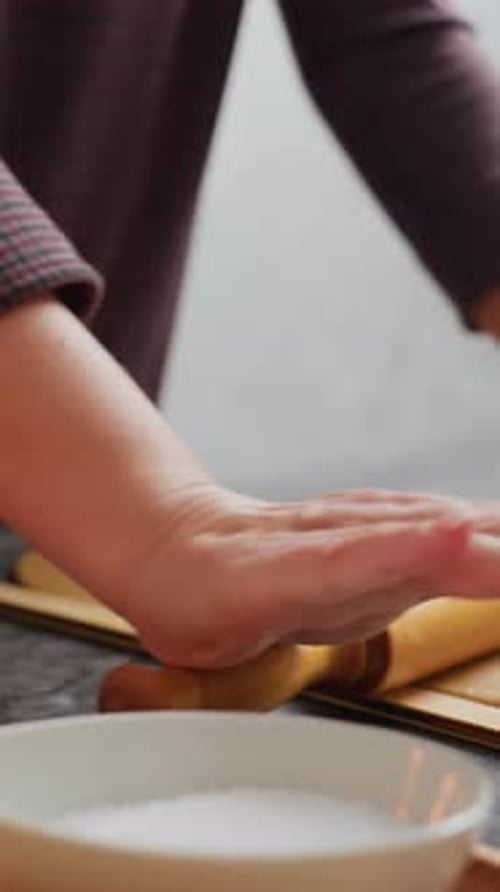 Woman Rolling Dough with Wooden Rolling Pin at Home