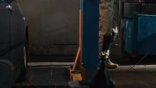 Unrecognizable Mechanic in Uniform Working in Car Service Center