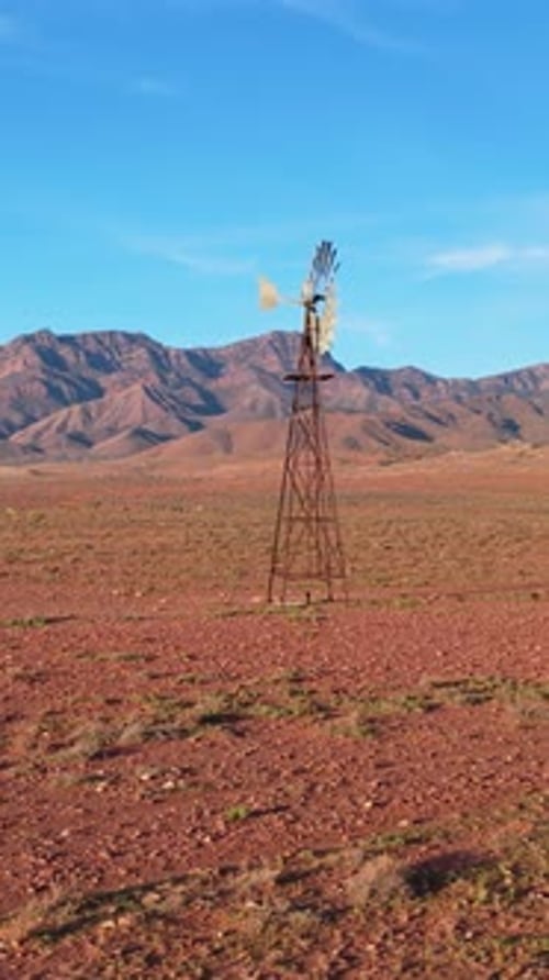 Vertical portrait rotating shot of windmill and Flinders Ranges, South Australia