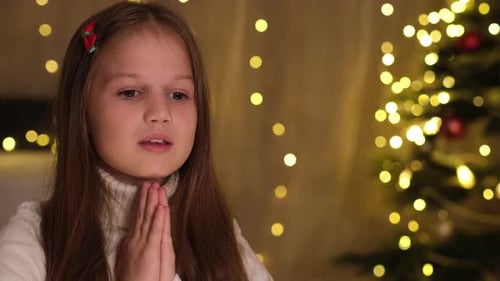 Girl Praying at Christmas Tree at Night