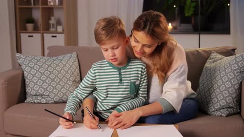 Smiling Woman and Boy Drawing Together at Home