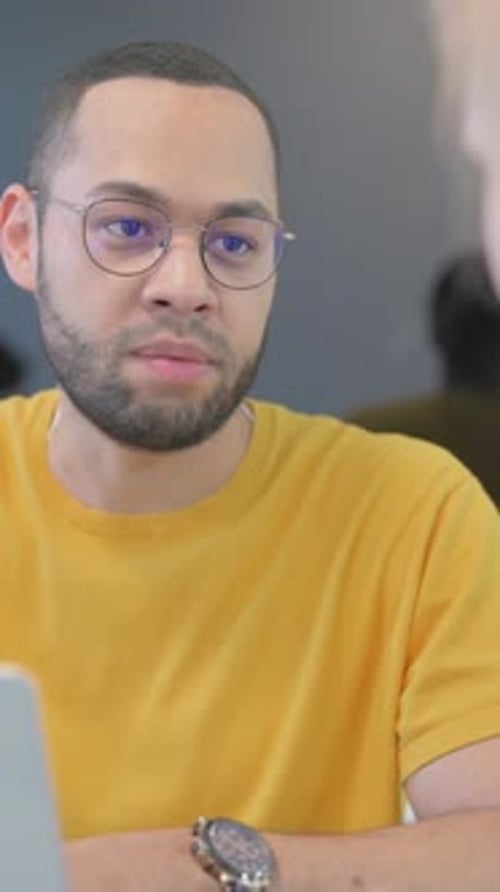 Close up of Mixed Race Man Talking with Female Colleague, vertical video