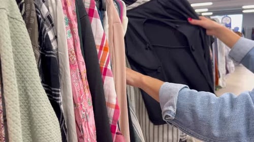Closeup of a Woman's Hands in a Store Examining and Choosing Clothes Women's Clothing From Natural