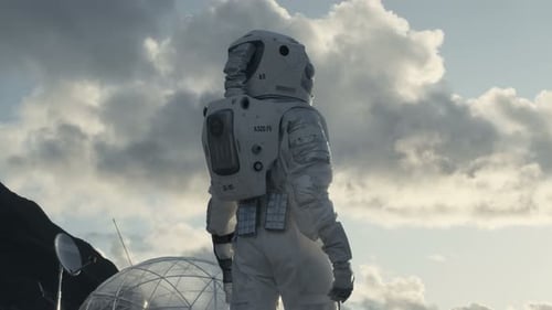 Following Shot of the Astronaut Looking Around on Frozen Alien Planet. In the Background His Base/