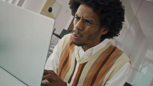Stressed Man Working at Laptop in Office