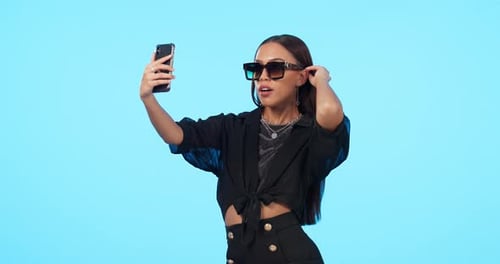 Selfie, fashion sunglasses and woman in studio isolated on blue background mockup