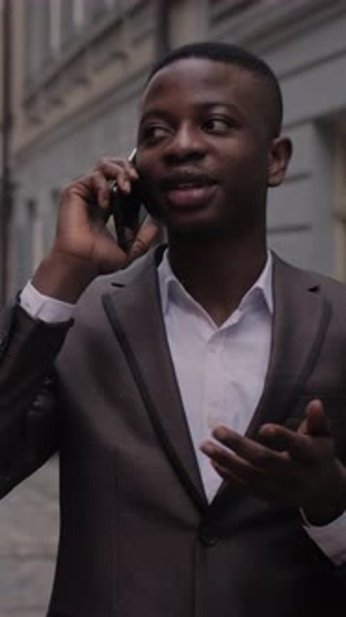 Young Man Talking on Phone in City Setting