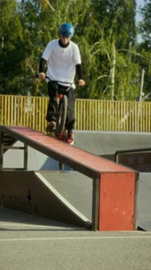 Young BMX Rider Grinding on Rail at Skatepark Ramp