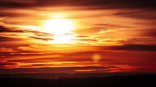 Timelapse of Dramatic Sunset Through Clouds in the Orange Sky Over the Horizon