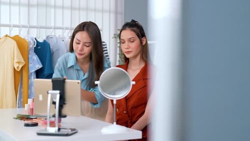 personas influyentes graban transmisiones en vivo en línea, disfrutando tomando una cámara de Vídeo con felicidad en el estudio