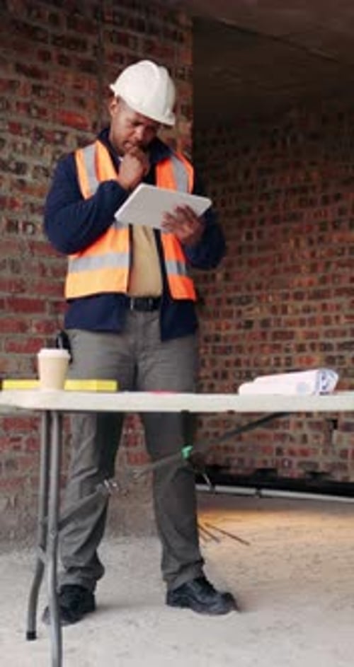 Builder, thinking and man with tablet in building, search or safety inspection with info on website