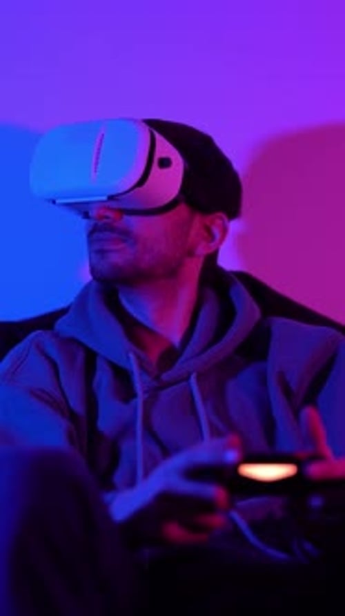 Männlicher Cybersport-Gamer mit Virtual-Reality-Brille und Controller beim Spielen