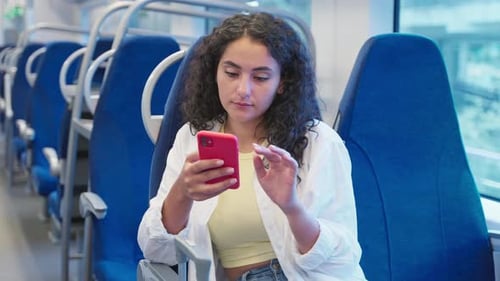 Pendlerin mit Telefon im Zug
