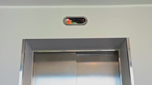 The Modern Elevator Door Featuring a Bright Red Indicator Light is Elegantly Positioned Within a