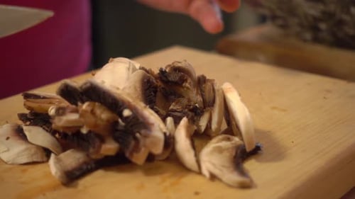 Slicing Mushrooms on a Wood Cutting Board