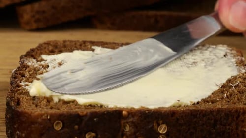 Spreading Butter on Brown Bread Slice Close Up