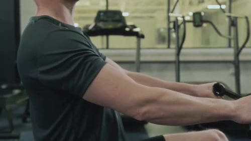 Athlete Pulling Cables on Seated Row Machine in Gym