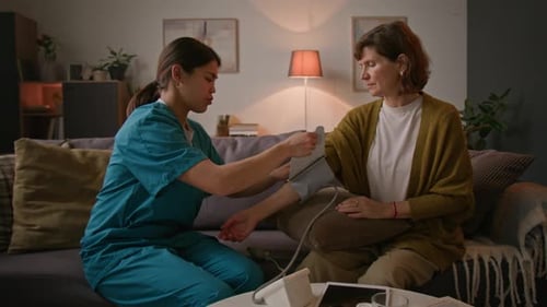 Medical Professional Checks Patient's Blood Pressure at Home
