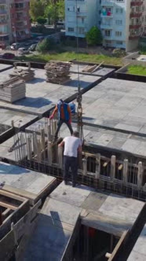 Vídeo vertical: Instalación de fachadas, corte de piedra y fabricación de metal en una construcción bulliciosa