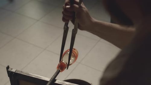 Glassblower Molding Shape of Glass Decor Element in Workshop