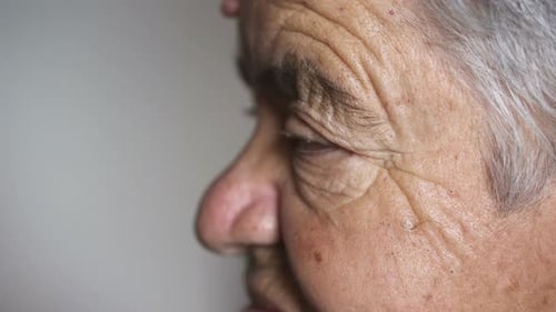 Close up on sad wrinkled eyes of old woman