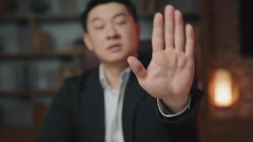 Man in Suit Holds Hand Up to Stop