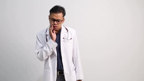 Doctor With Toothache Standing in Front of White Background