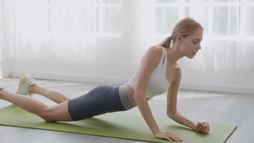 Woman Exercising Doing Planks at Home on Mat