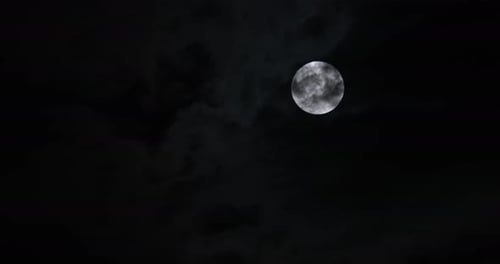 Full Moon behind Dark Clouds at Night