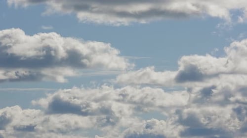 Fluffy White Clouds Moving Across Blue Sky