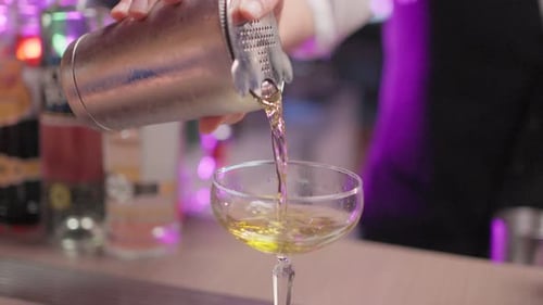 Close up of Caucasian profession bartender making a cocktail at a bar.