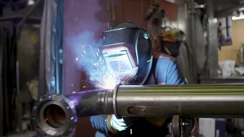 Schweißarbeiten Schweißer Metallschweißrohr Funken fliegen aus der Fabrik für industrielle Fertigung