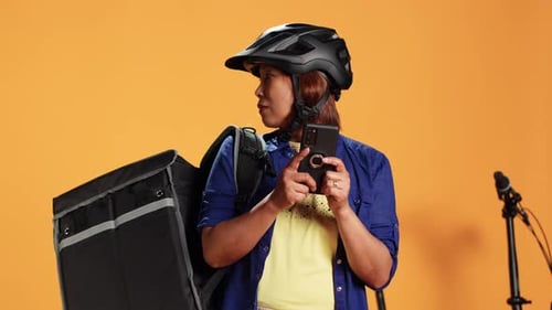 Woman With Delivery Bag Using Smart Phone