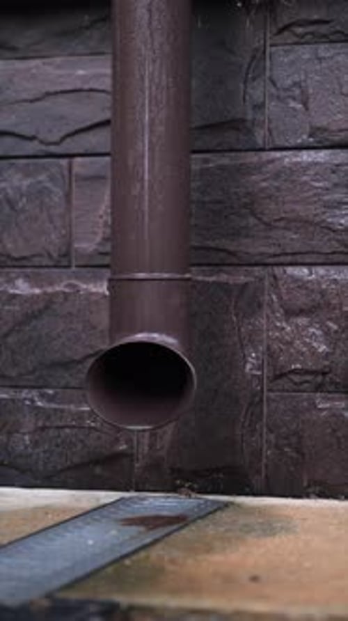 Water Flowing Down Brown Metal Downspout