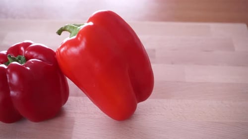 Two Red Peppers on a Wooden Cutting Board