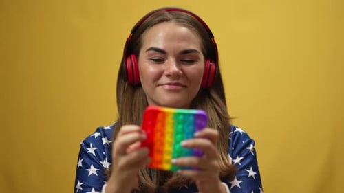 Happy Woman Enjoying Popping Dimples in Slow Motion Listening to Music in Headphones