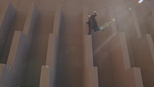 Young Adult Jumps Across Urban Concrete Structures