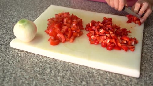 Dicing Red Pepper with Fresh Vegetables on Cutting Board