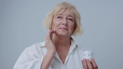 Senior Woman Applying Facial Cream for Skincare