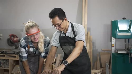 Carpenters are working together at workshop.