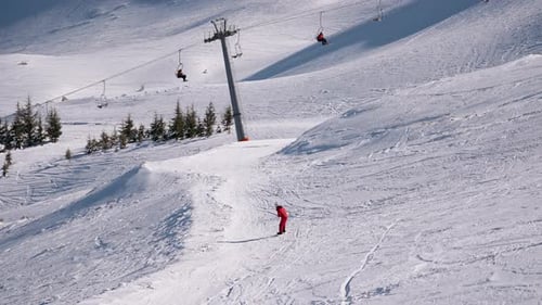 Skier Under a Chairlift on a Snowy Mountain – Winter Sports and Alpine Landscape
