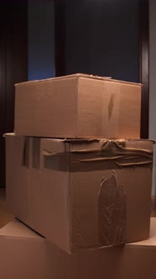 Vertical Video Man Stacking Cardboard Boxes During Home Moving Process