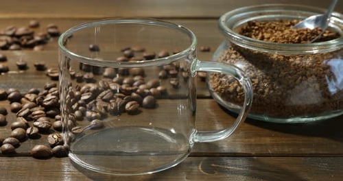 Adding instant coffee to glass mug with beans