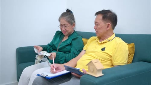 On a holiday, an elderly couple is relaxing at home, keeping a record of household
