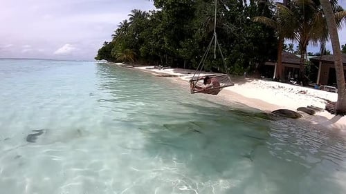 Down Syndrome Child Enjoying the Swing on The Beach