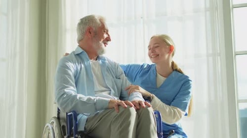Elderly Man and Caregiver Talking Indoors