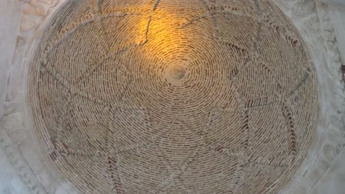 We see the circular dome of the Siti Radviyye Tomb made of red and white stones.