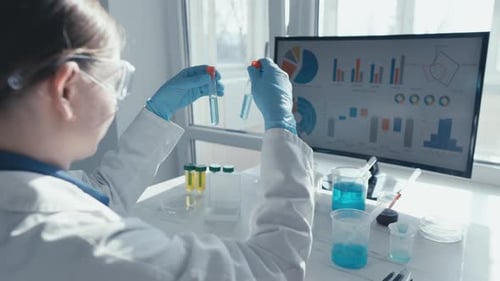 Female Scientist Examining Test Tubes in Bright Lab