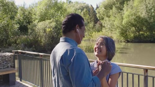 Happy Couple Listening to Music with Headphones and Dancing in Park 4549 Years