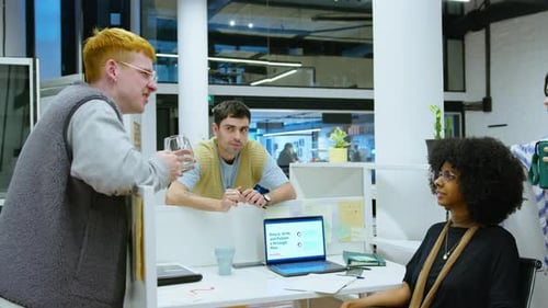Young Colleagues Discussing Business Ideas Over Cubicle Wall in the Office